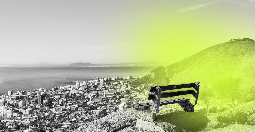 A black-and-white cityscape overlooks the ocean, with a bright yellow-green spotlight on a solitary park bench on a rocky hill. Calm, contemplative mood.